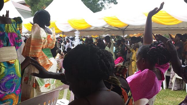 Christians in Nkokonjeru raising their hands in prayer, celebrating Sr. Lucia