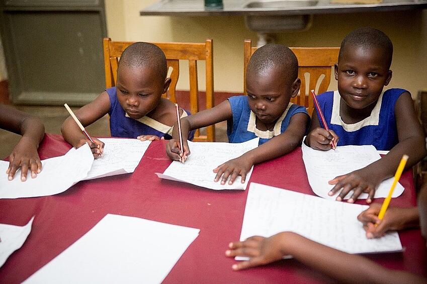CARITAS Children Butono Veronica, Daphine Nakayiza, and Mirembe Grace writing letters to their sponsors (Photo Credit: Tina LeAnn Photography)