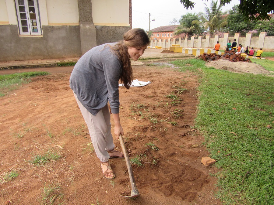 Young woman hoeing weeds.