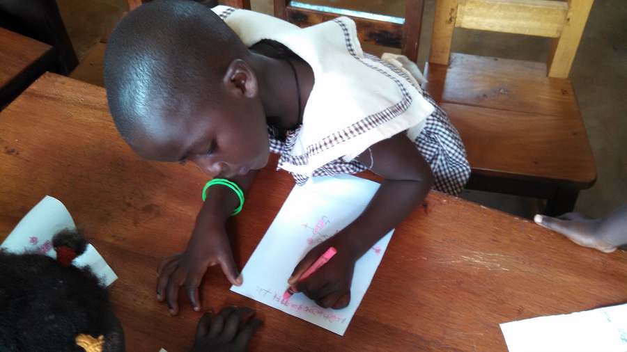 A student from baby class, three to four-year-olds, enjoy coloring with a gift of new crayons. 