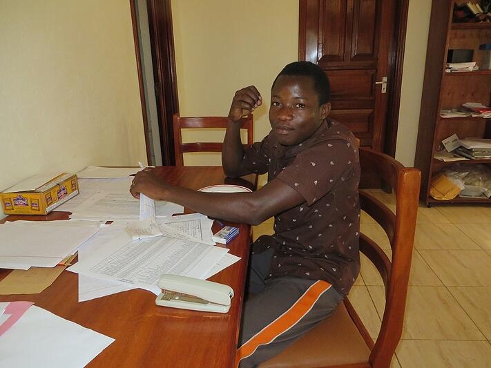 James writing at the desk of the CARITAS Residential Learning Center
